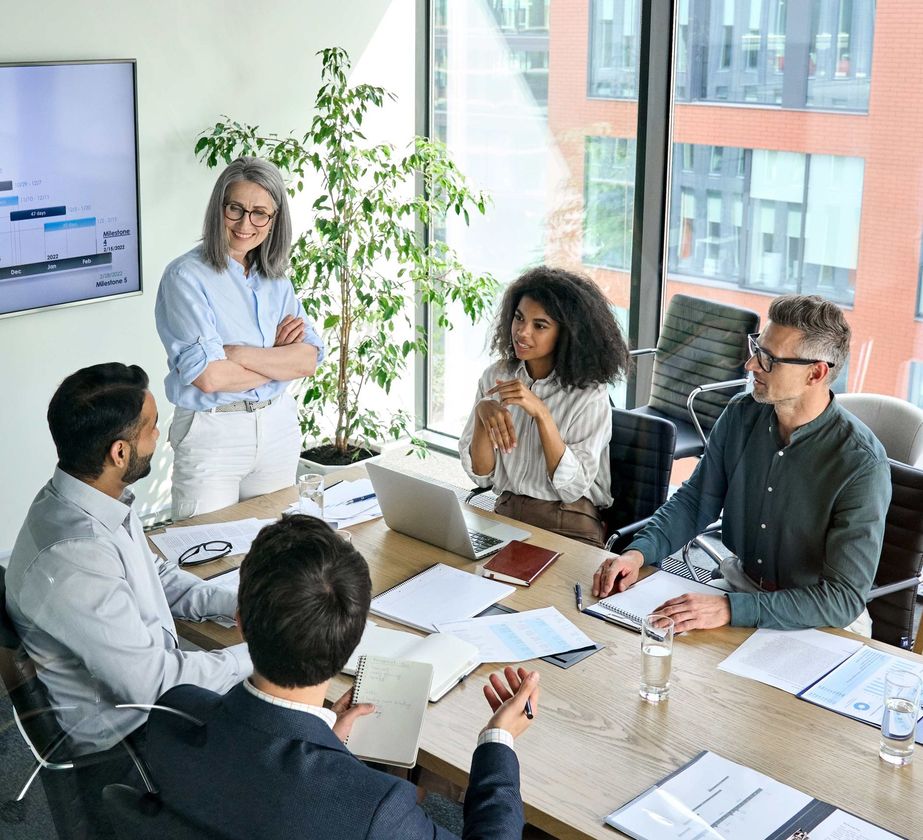a group of people are sitting around a table in a conference room