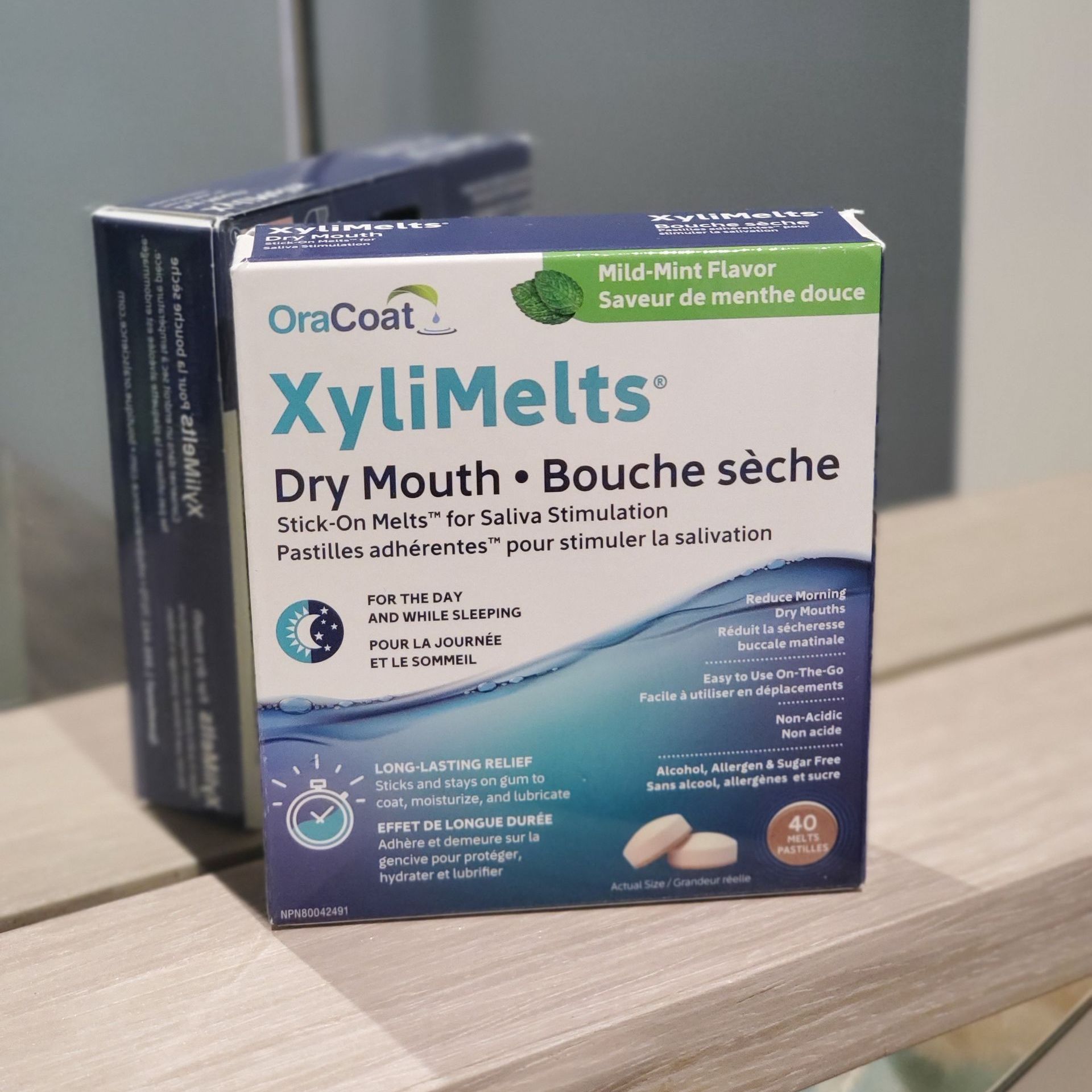 Box of OraCoat XyliMelts for dry mouth with mild-mint flavor and stick-on saliva stimulation.