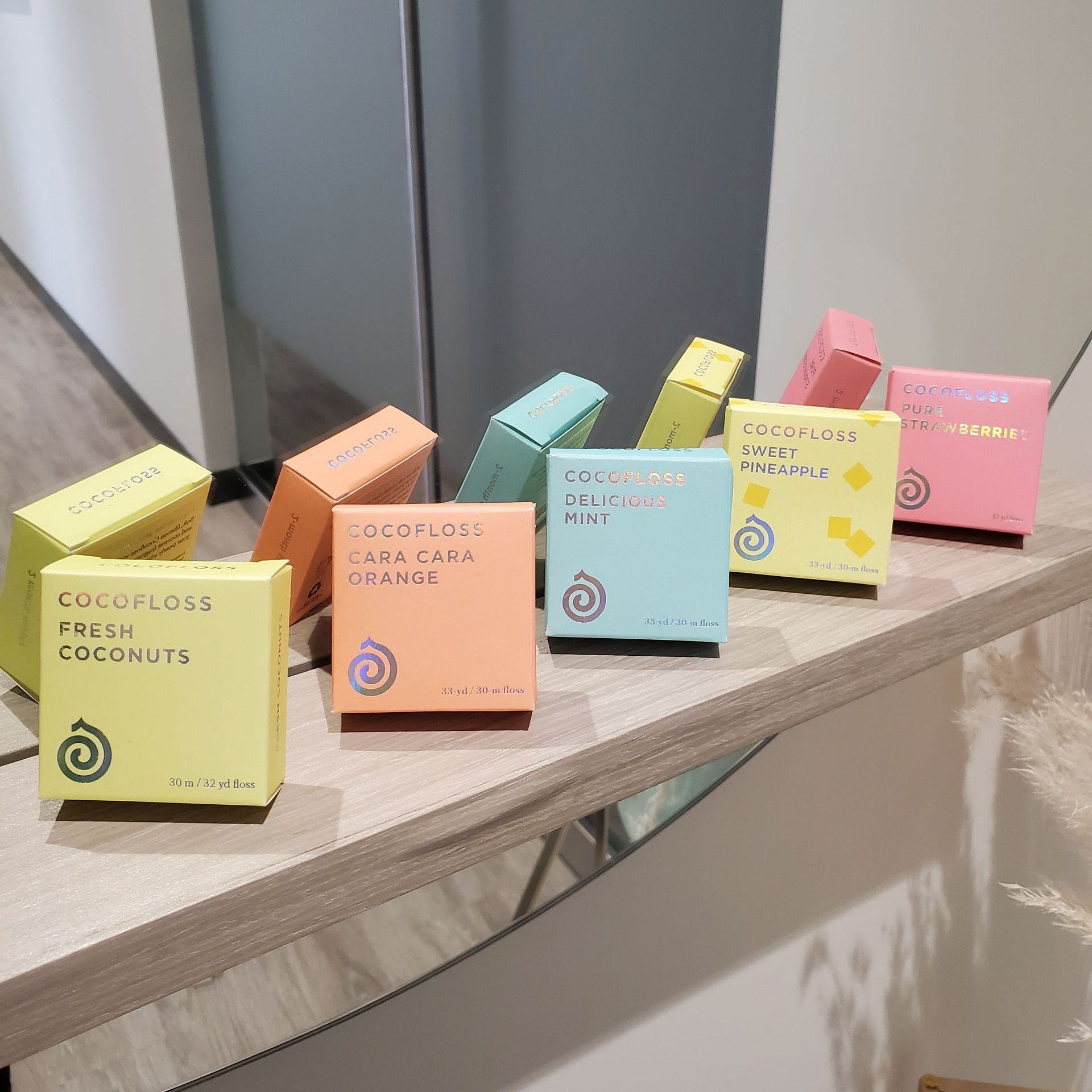 Boxes of scented wax melts, various colors, arranged on a shelf in a room.