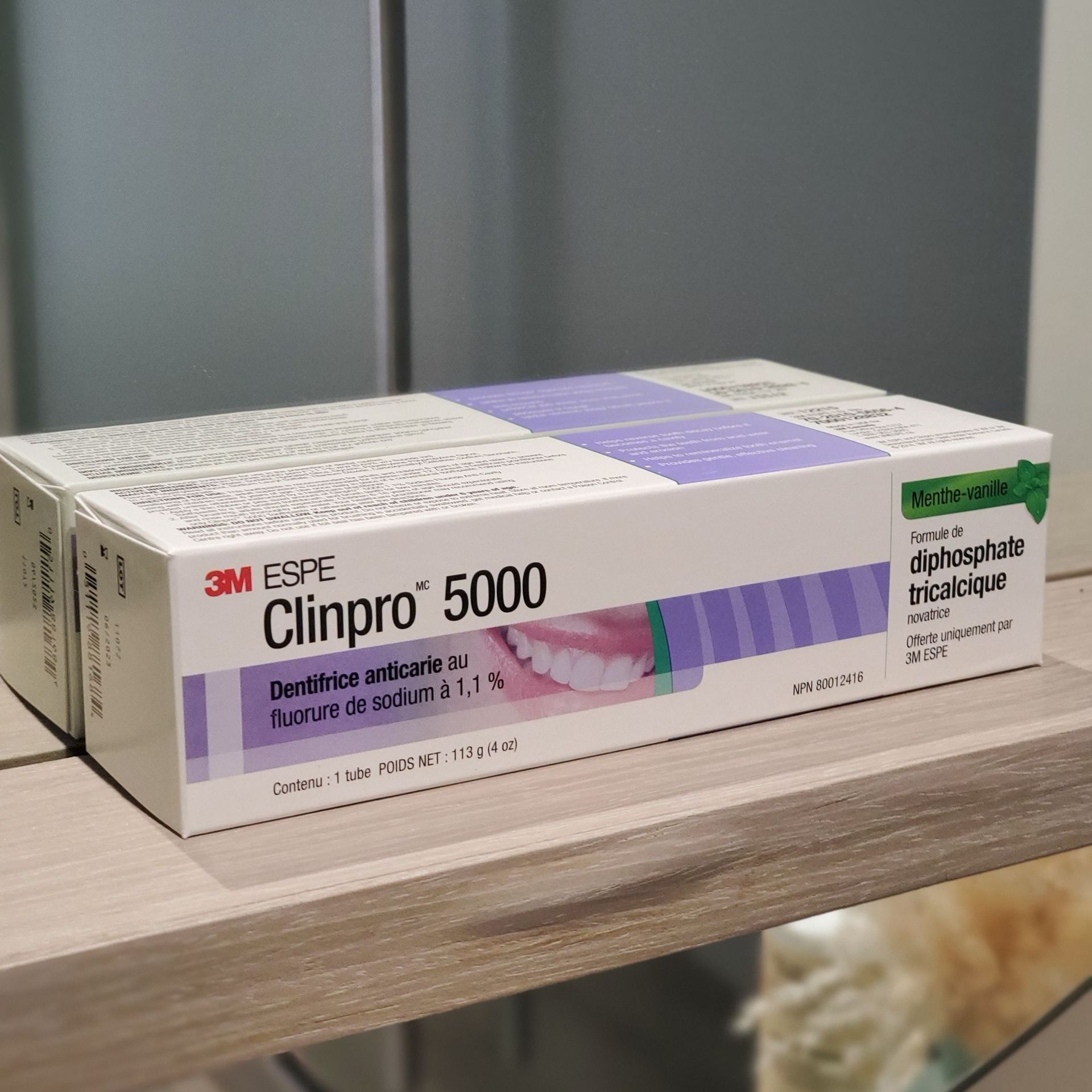 Box of 3M Clinpro 5000 toothpaste with purple and white packaging on a shelf.