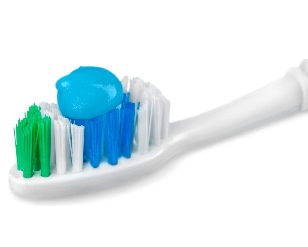 Toothbrush with blue toothpaste on bristles.
