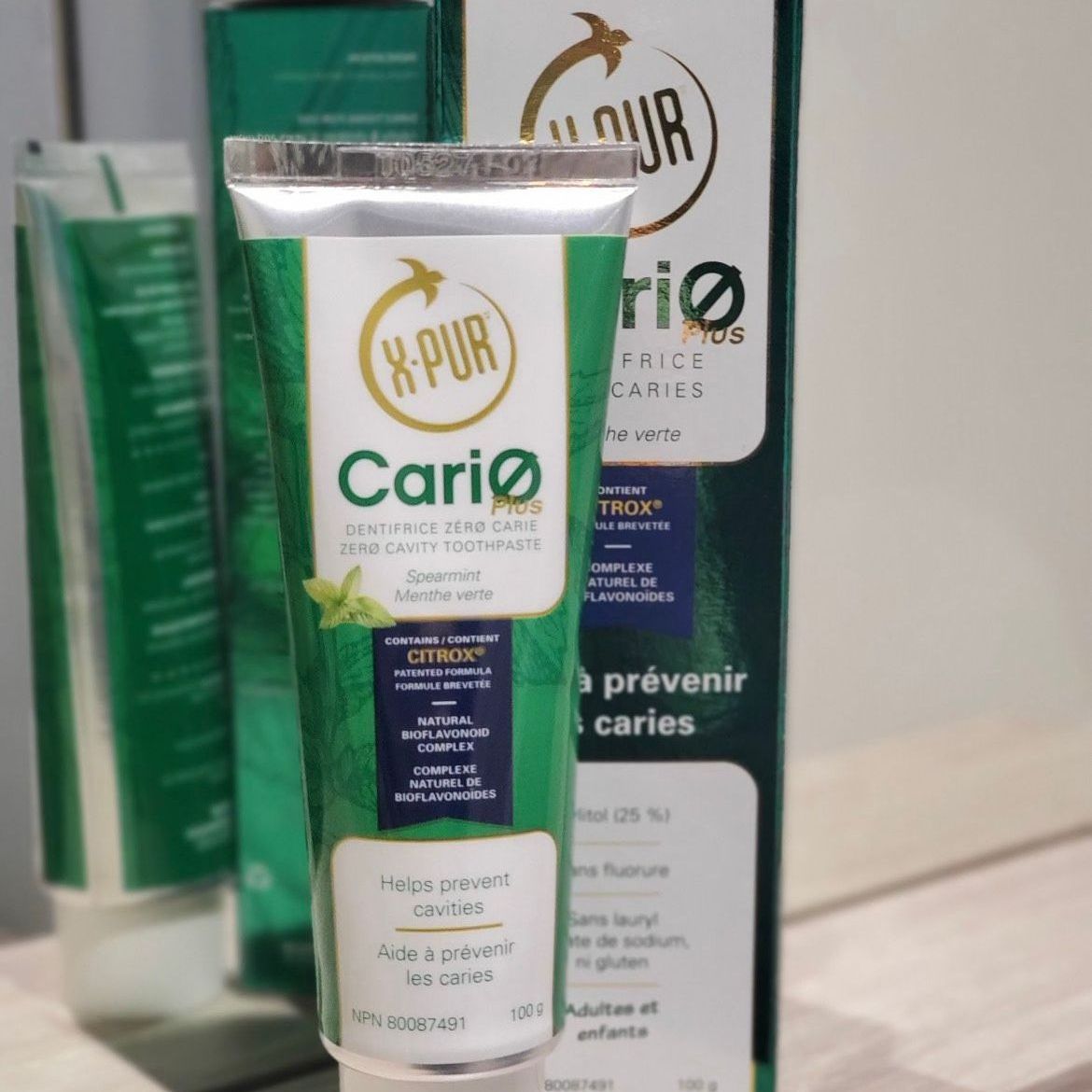 Tube of Cariø toothpaste with a green and white color scheme, mint-flavored, near a box.