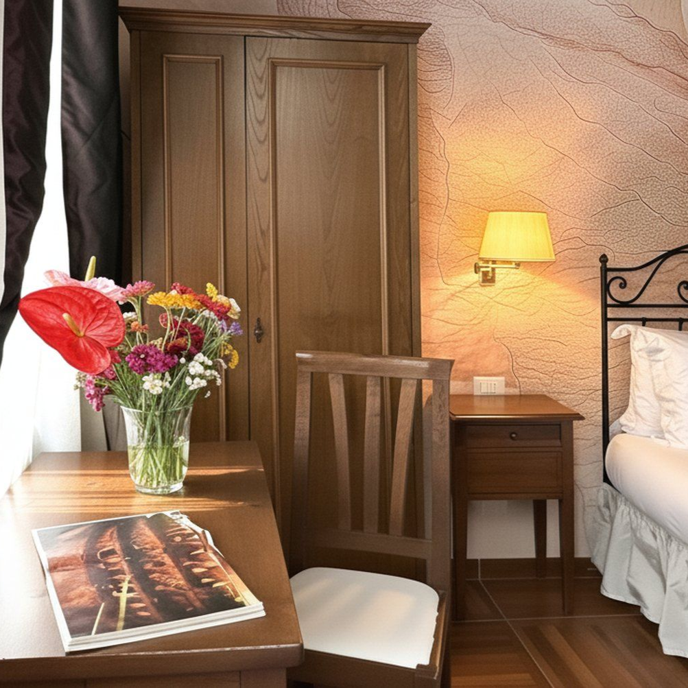 Chambre d'hôtel confortable avec une armoire en bois, un bureau orné de fleurs et une table de chevet.