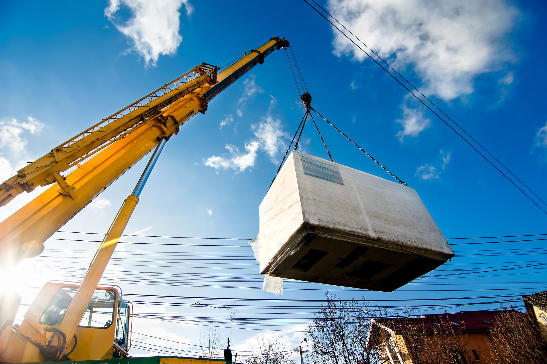Industrial crane operating and lifting an electric generator.