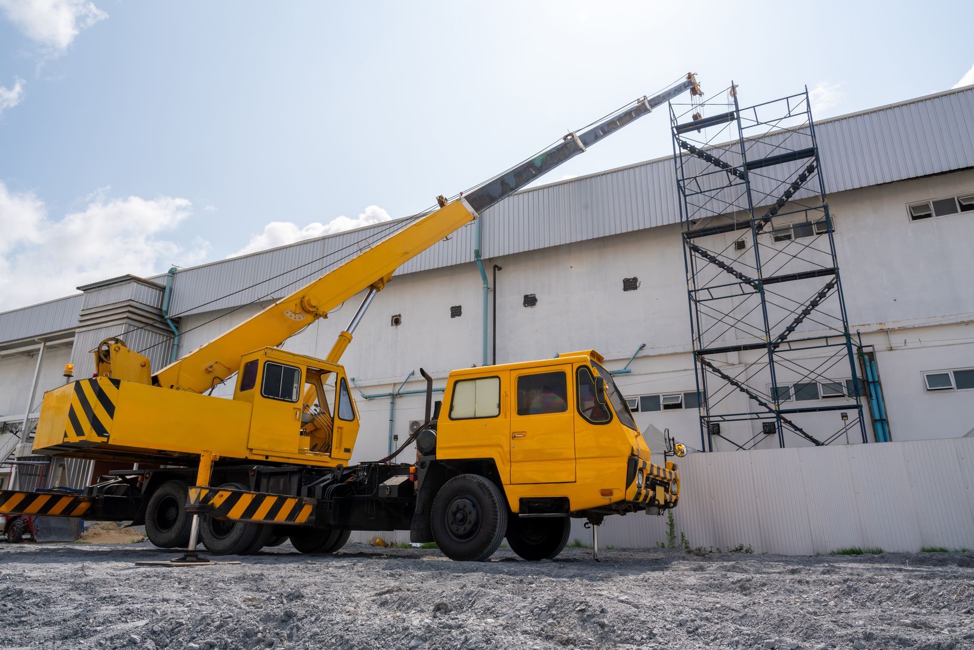 Crane service lifting materials at an industrial construction site.