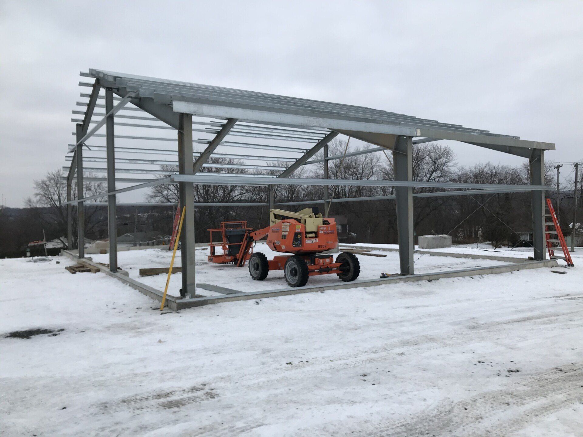 A large metal structure is being built in the snow.
