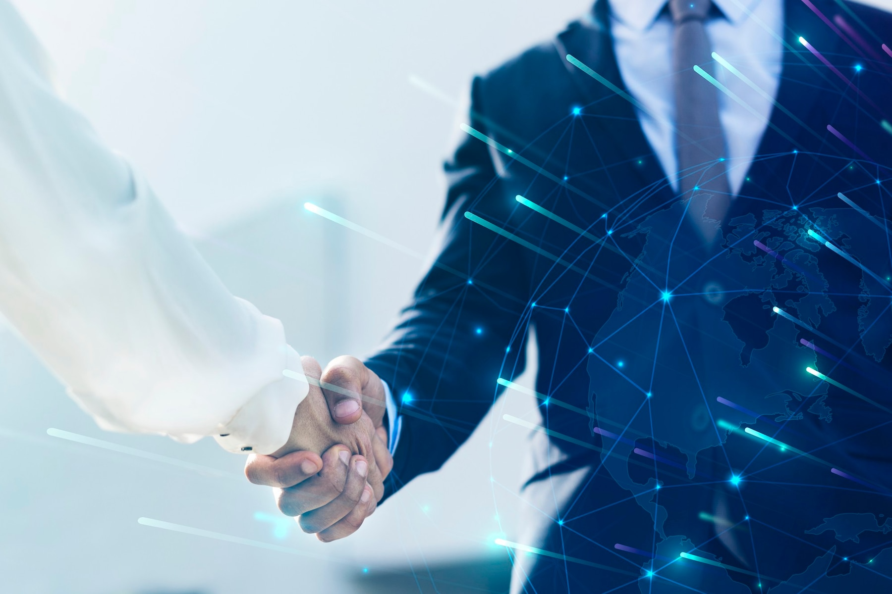 Two people shaking hands, one in a dark suit with blue digital network overlay