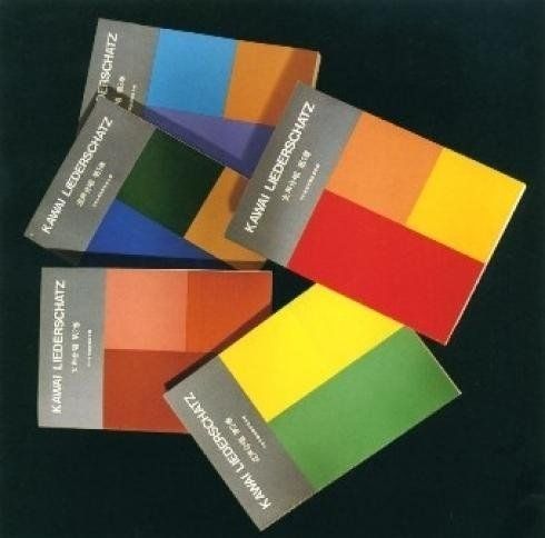 Quattro scatole di giocattoli Kenner colorate disposte in una pila diagonale su uno sfondo scuro.