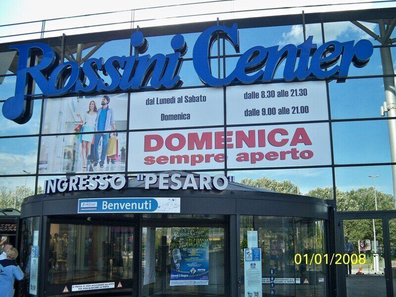 Vetrina del Rossini Center con grande insegna blu e striscione rosso