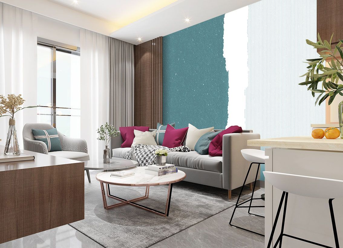 Luminoso soggiorno moderno con divano grigio, cuscini rosa, parete d'accento color verde acqua e tavolo da pranzo bianco con frutta