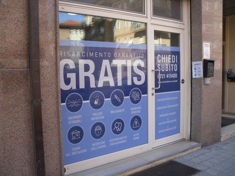 Vetrina con insegne blu che pubblicizzano “GRATIS” e “CREDITO SUBITO” in italiano.
