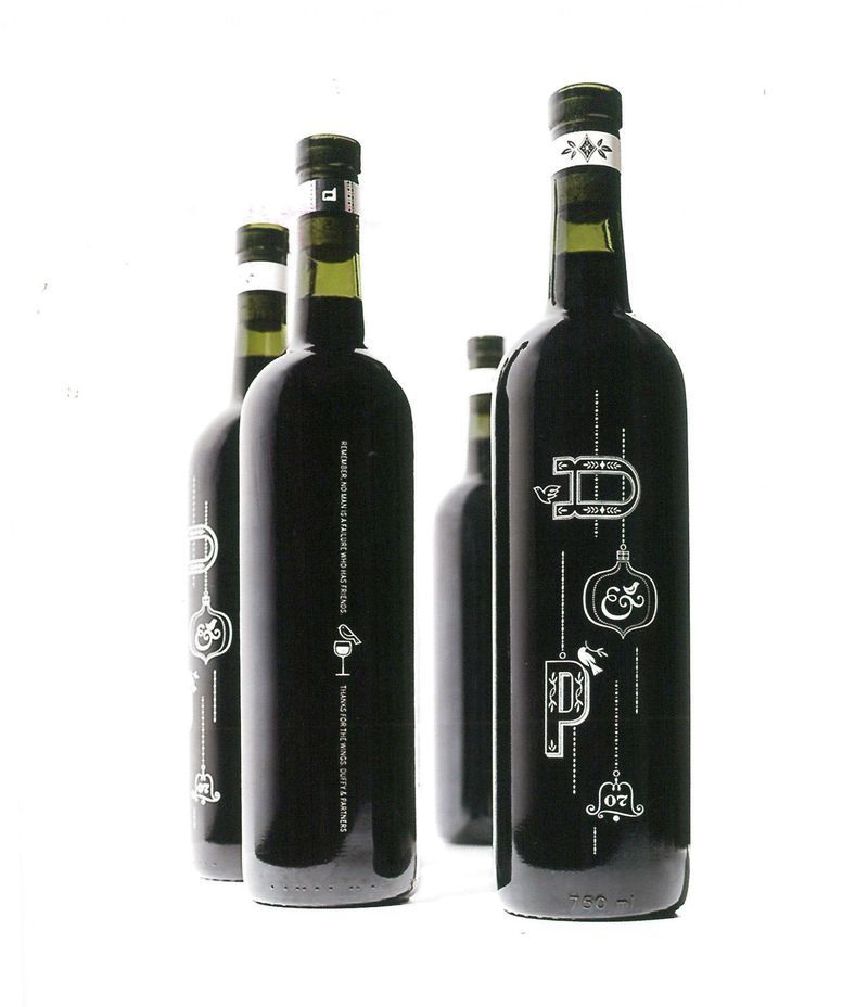 Tre bottiglie di vino scuro su sfondo bianco, con etichette bianche sulla parte frontale.