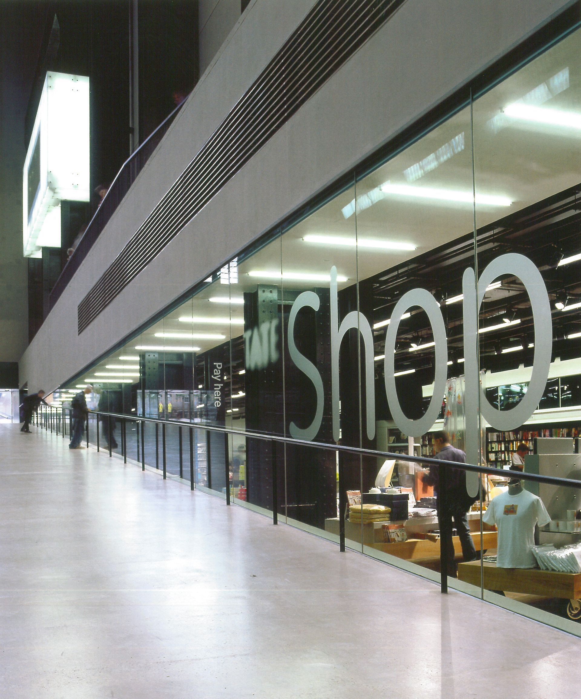 Corridoio di un moderno centro commerciale con vetrine in vetro e una grande insegna
