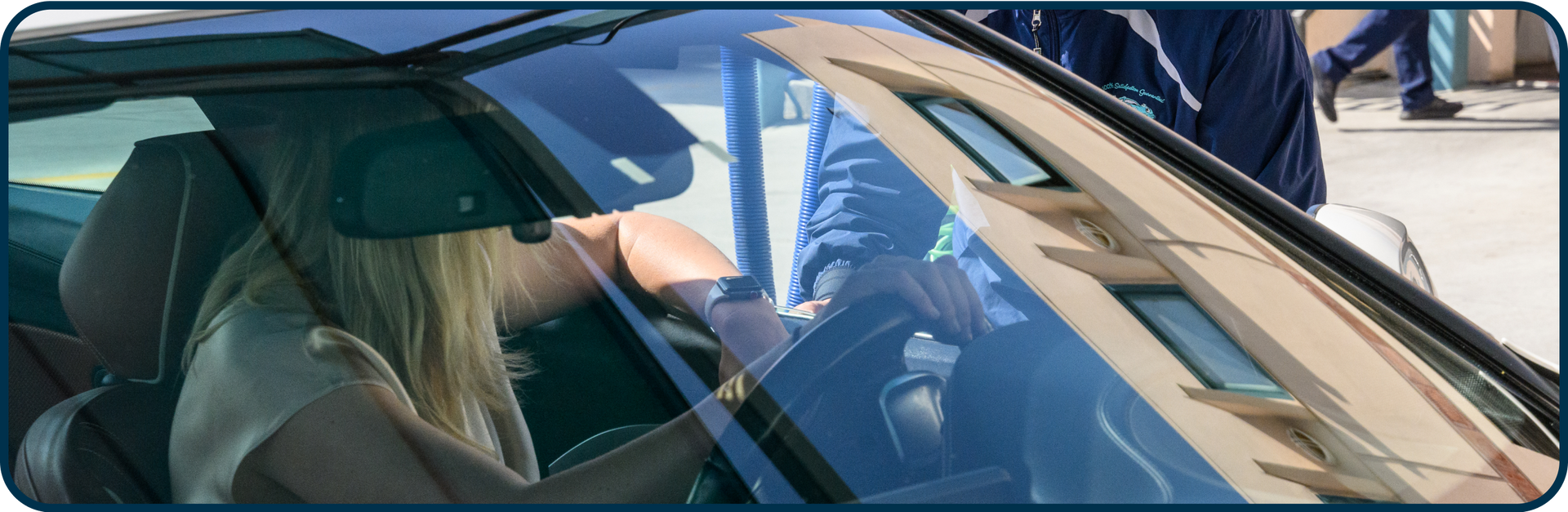 A woman is sitting in the driver 's seat of a car.