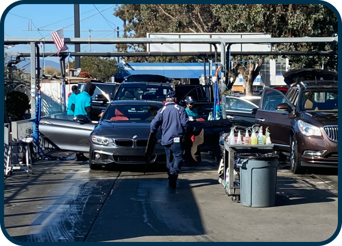 A man is washing a car in a car wash