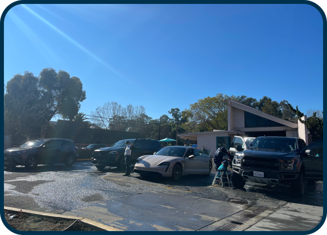 A row of cars are parked in front of a house