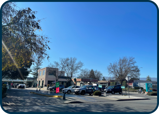 A parking lot with cars parked in front of a building