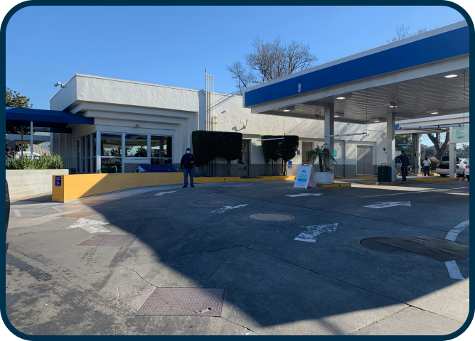 A man standing in front of a gas station with the number 1 on it
