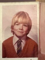 A old colour photo of a young boy. 