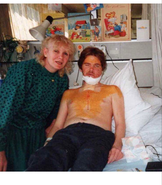 A man in a hospital bed with an older woman.