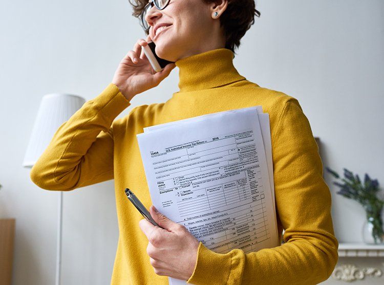 Woman Holding Papers — Madison, WI — EXACT Accounting & Financial Services Woman Holding Papers — Madison, WI — EXACT Accounting & Financial Services