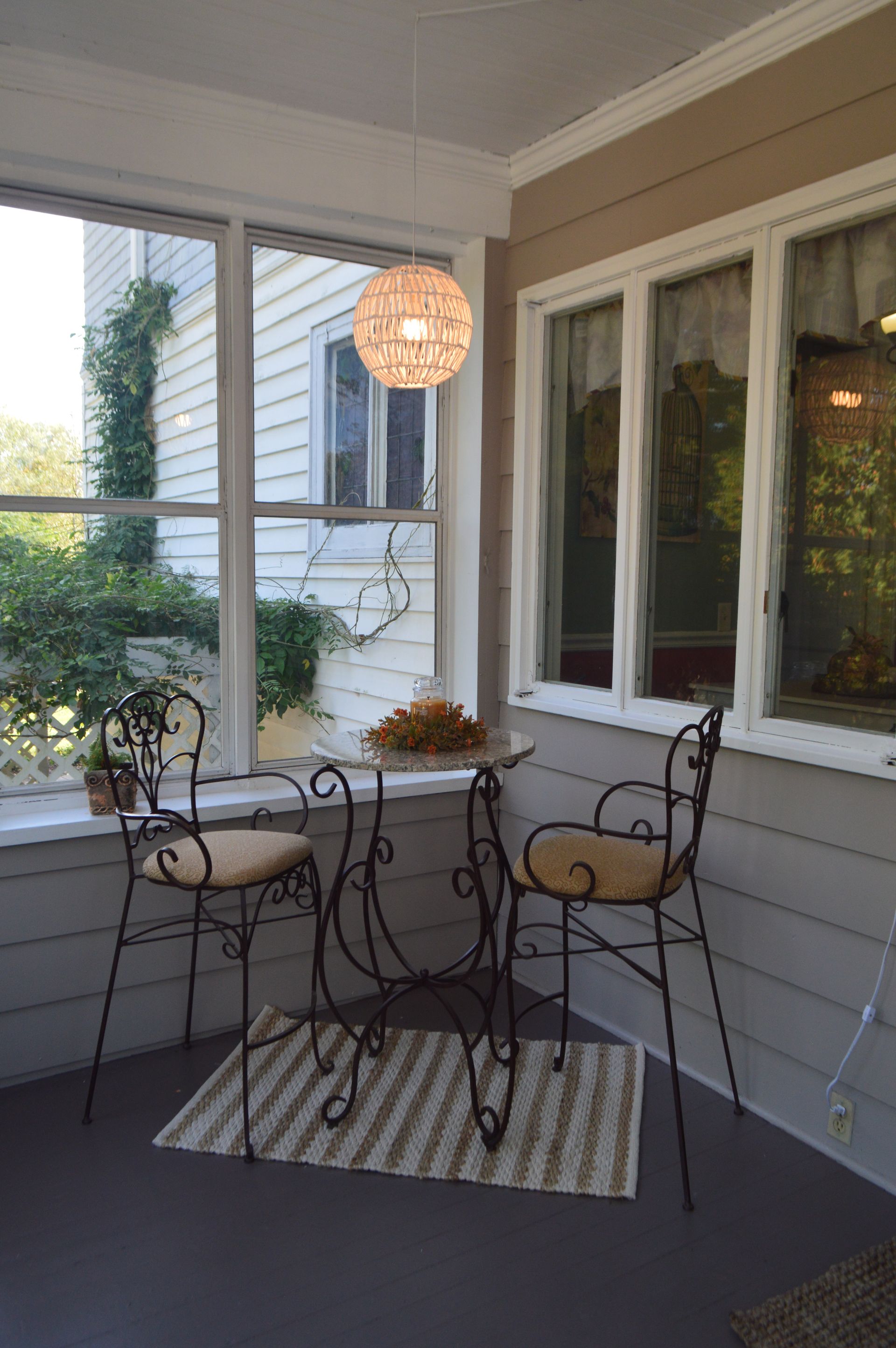 a porch with a table and chairs and a lamp hanging from the ceiling