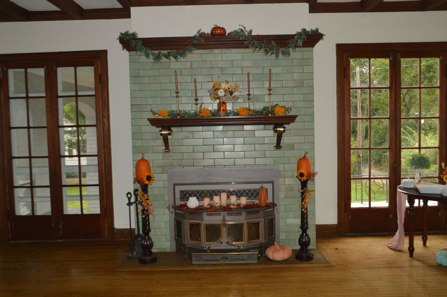 a fireplace decorated for fall with pumpkins and candles