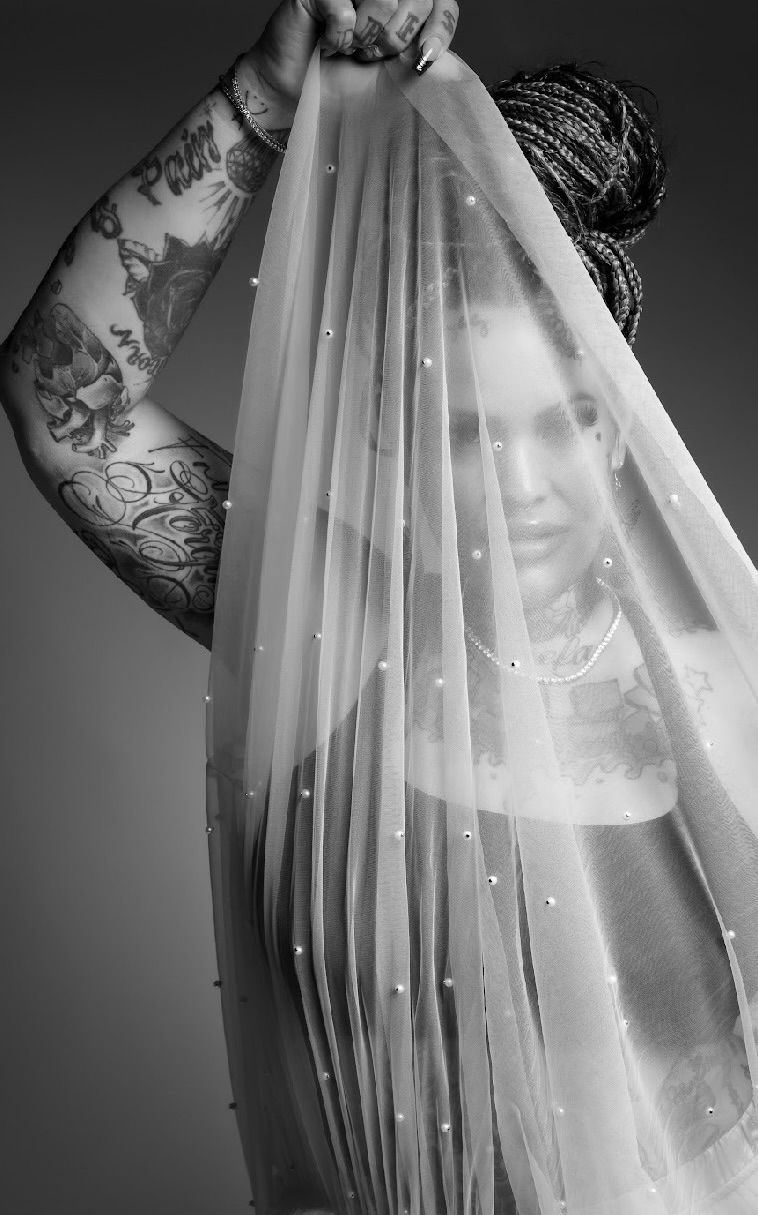 Smiley Rose Lewis, founder of House of Lacrimae, behind a pearl-studded veil