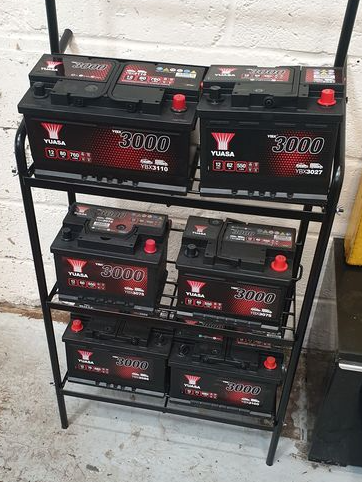 a shelf filled with a variety of batteries .