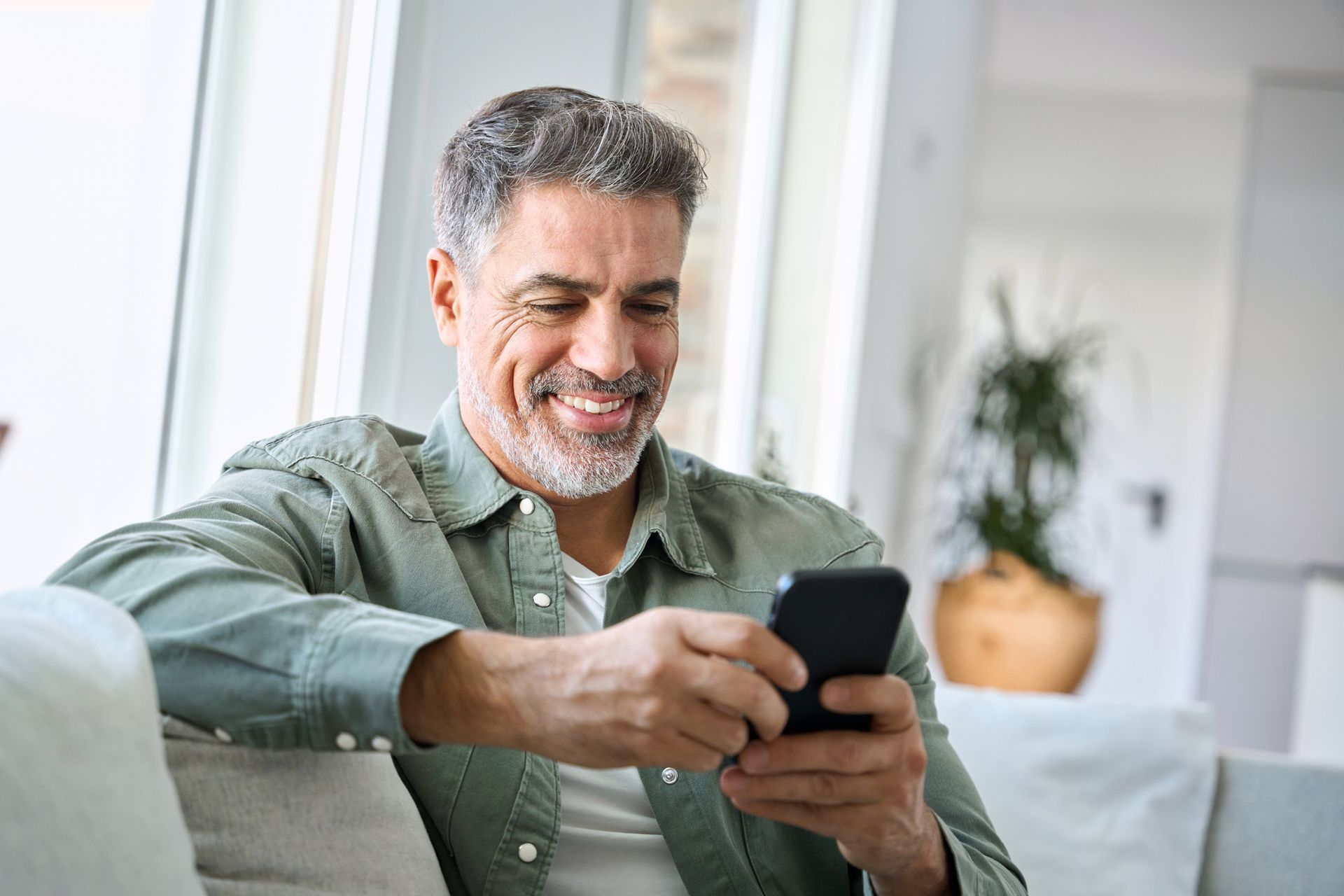 a man smiling looking at his cell phone