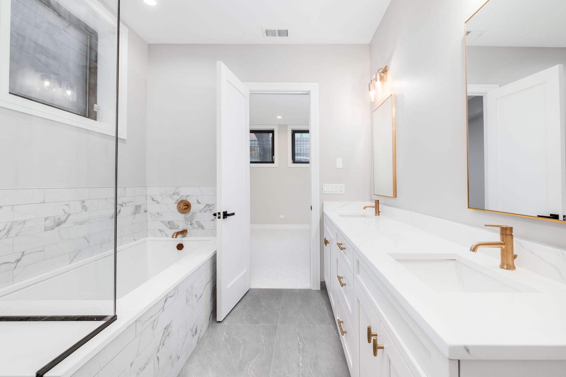 Luxurious white master bathroom with gold hardware and faucets