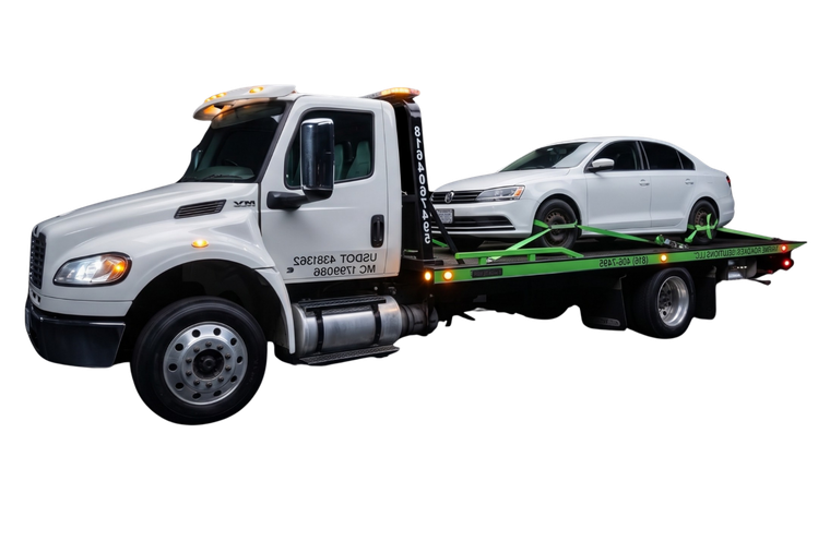 White tow truck carrying a white sedan on a flatbed tow bed
