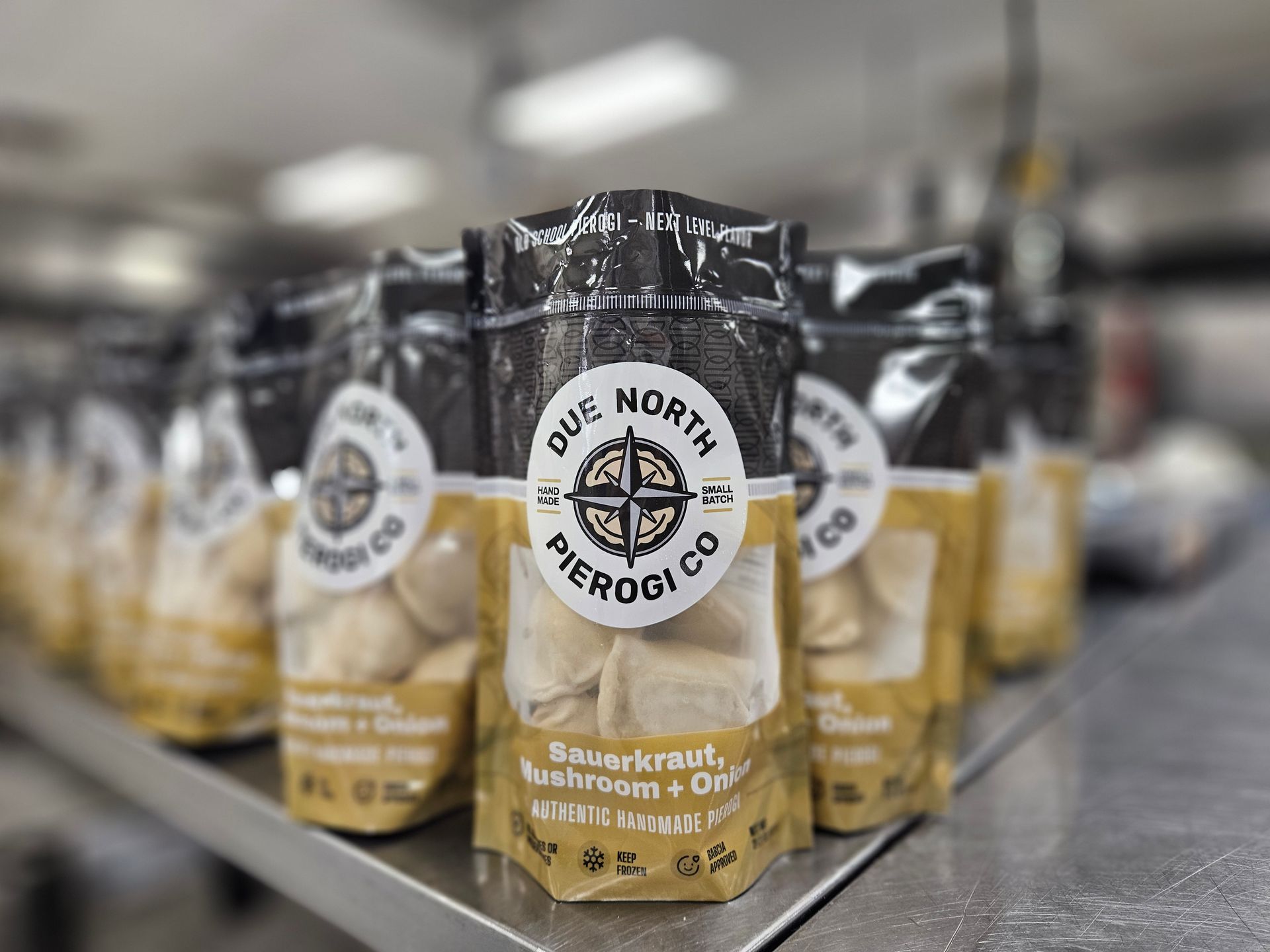 Row of Due North coffee bags on a store shelf, with one bag in sharp focus.