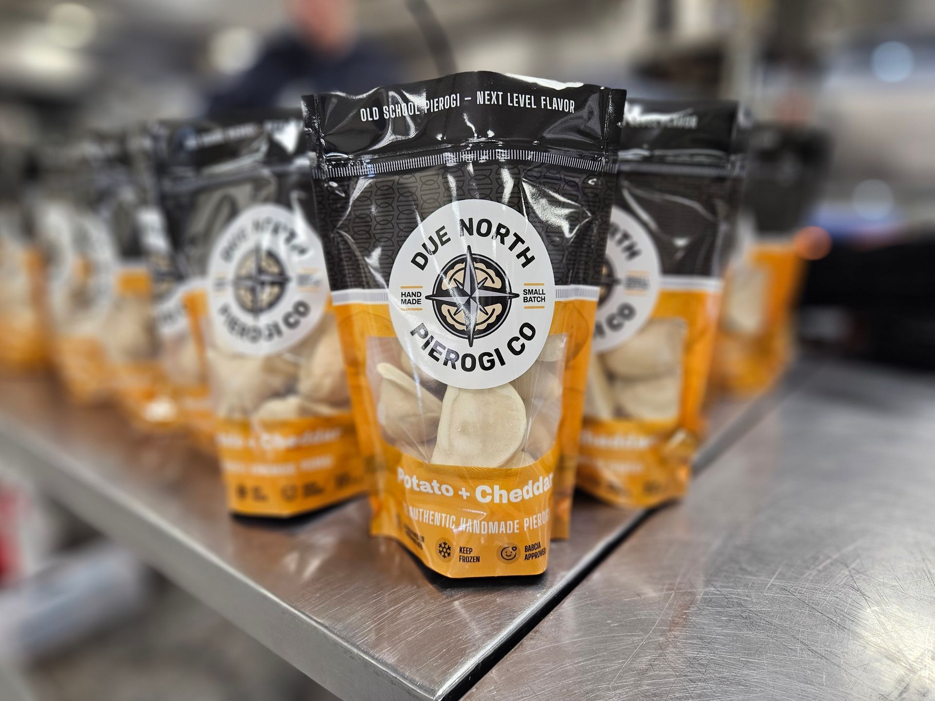 Several bags of white cheddar popcorn on a store shelf, with one bag in focus.