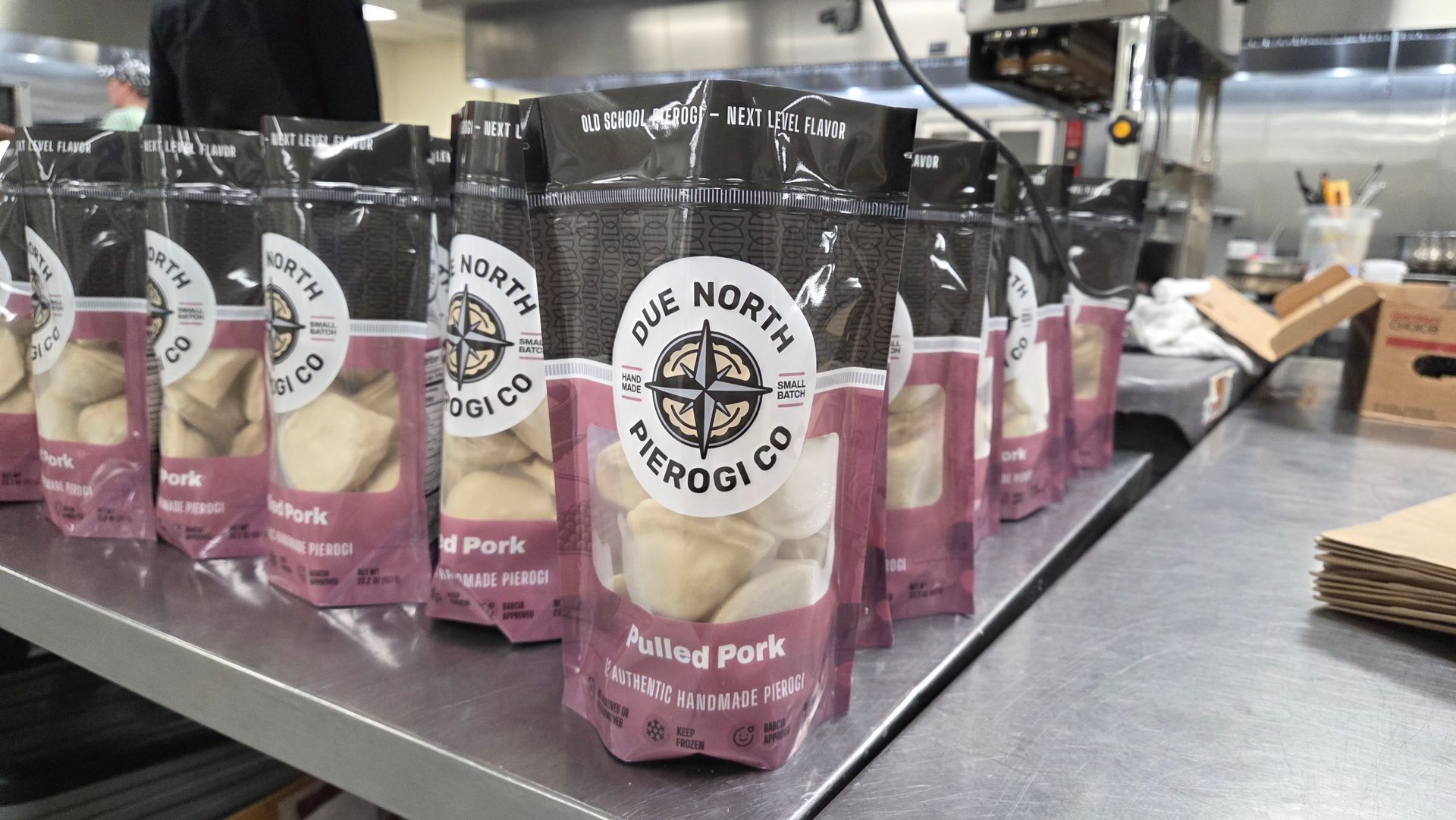 Pink and black pet food pouches displayed on a store shelf, with one bag labeled “Bulldog Pouch.”