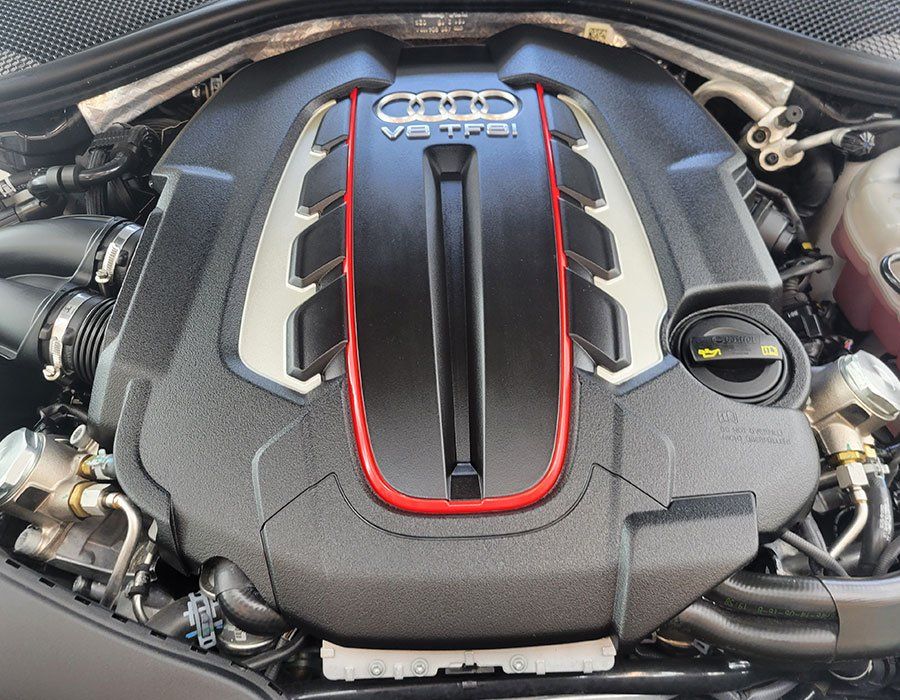 Audi V6 TFSI engine, black cover with red accents, in an engine bay.