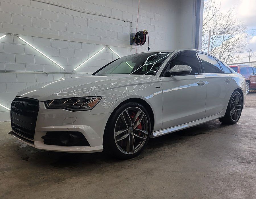 White Audi sedan in a garage, showcasing its exterior.