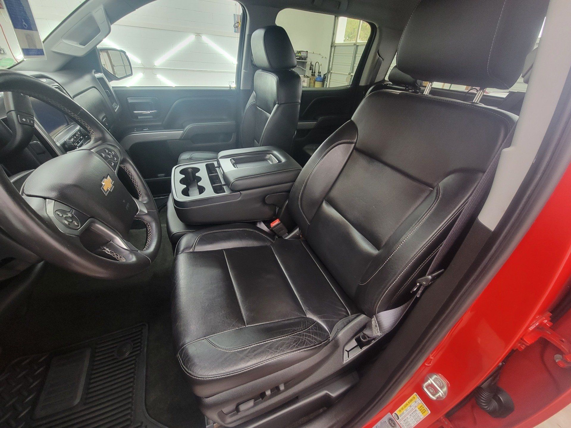 Red truck interior with black leather seats, steering wheel, and center console.