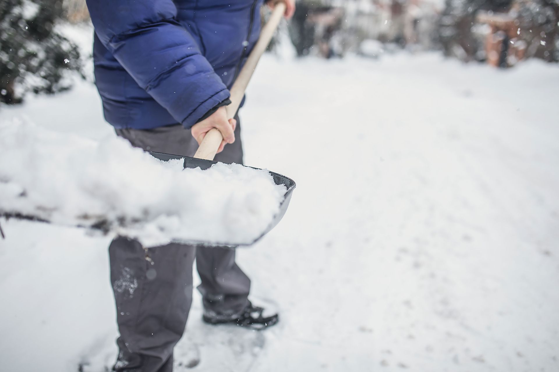 Man Removes Snow with a Shovel — Troy, NY — Dobert’s Landscaping LLC