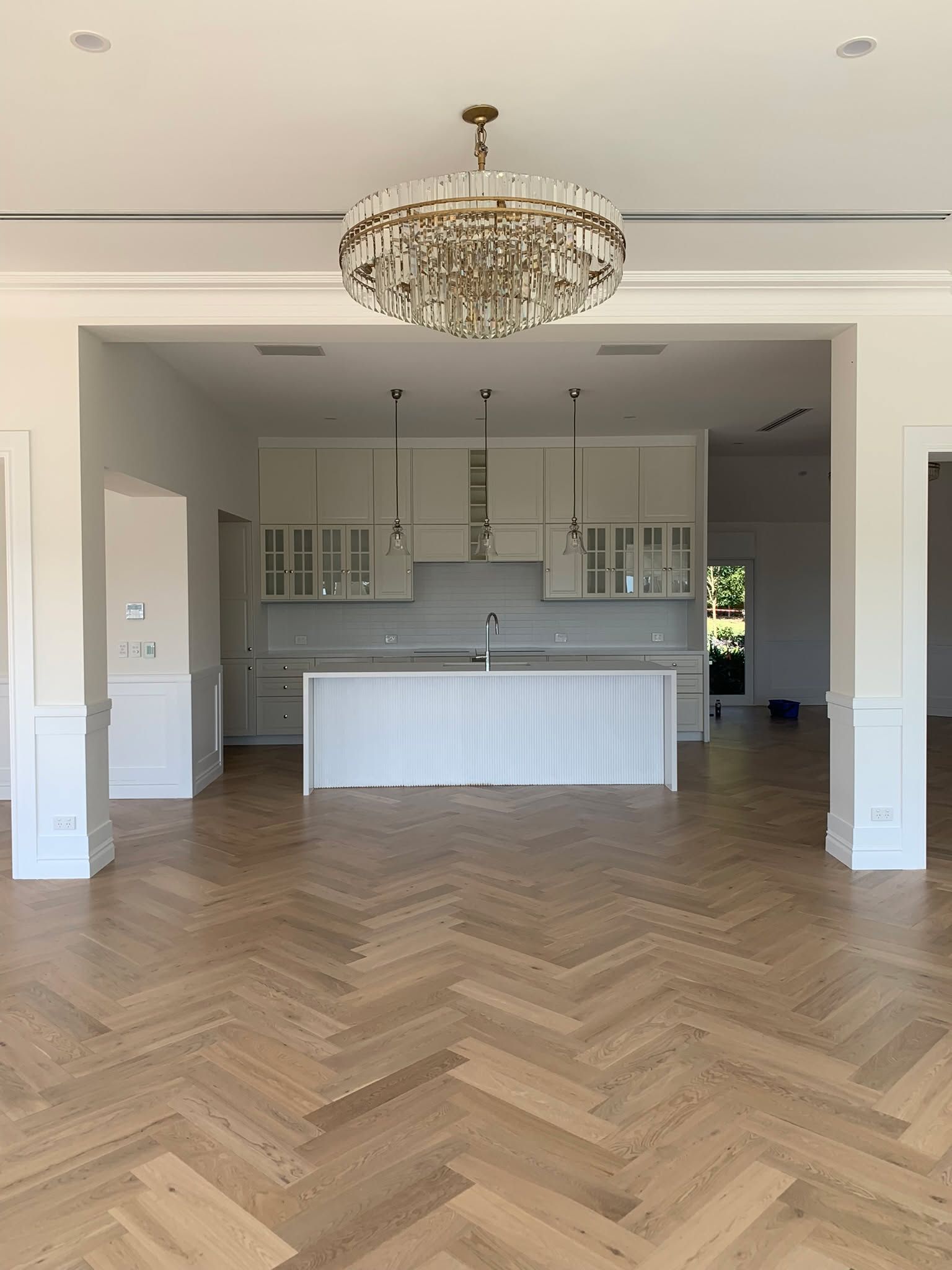 An empty kitchen with a chandelier hanging from the ceiling