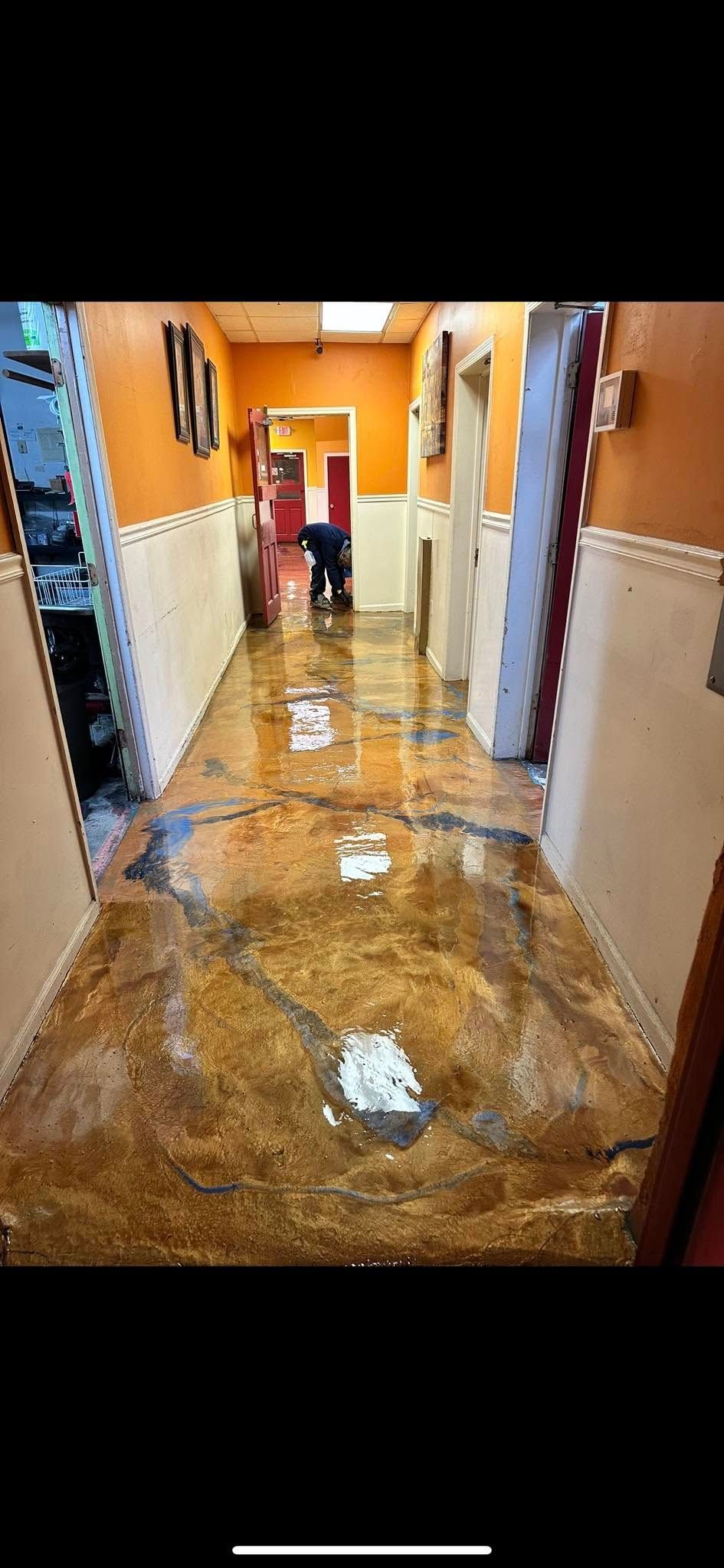 Flooded hallway with water covering the floor and orange walls on both sides