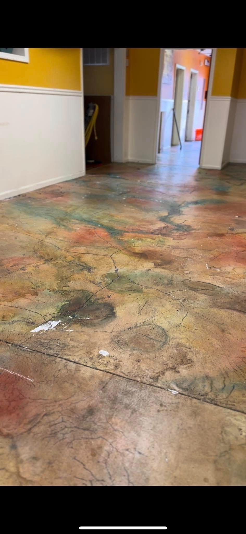 Colorful worn hallway floor with walls and a doorway in the distance