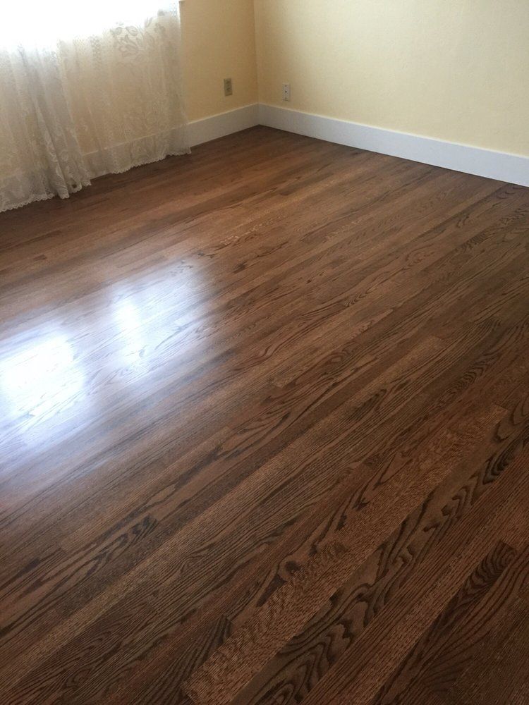 A bedroom with hardwood floors and yellow walls.