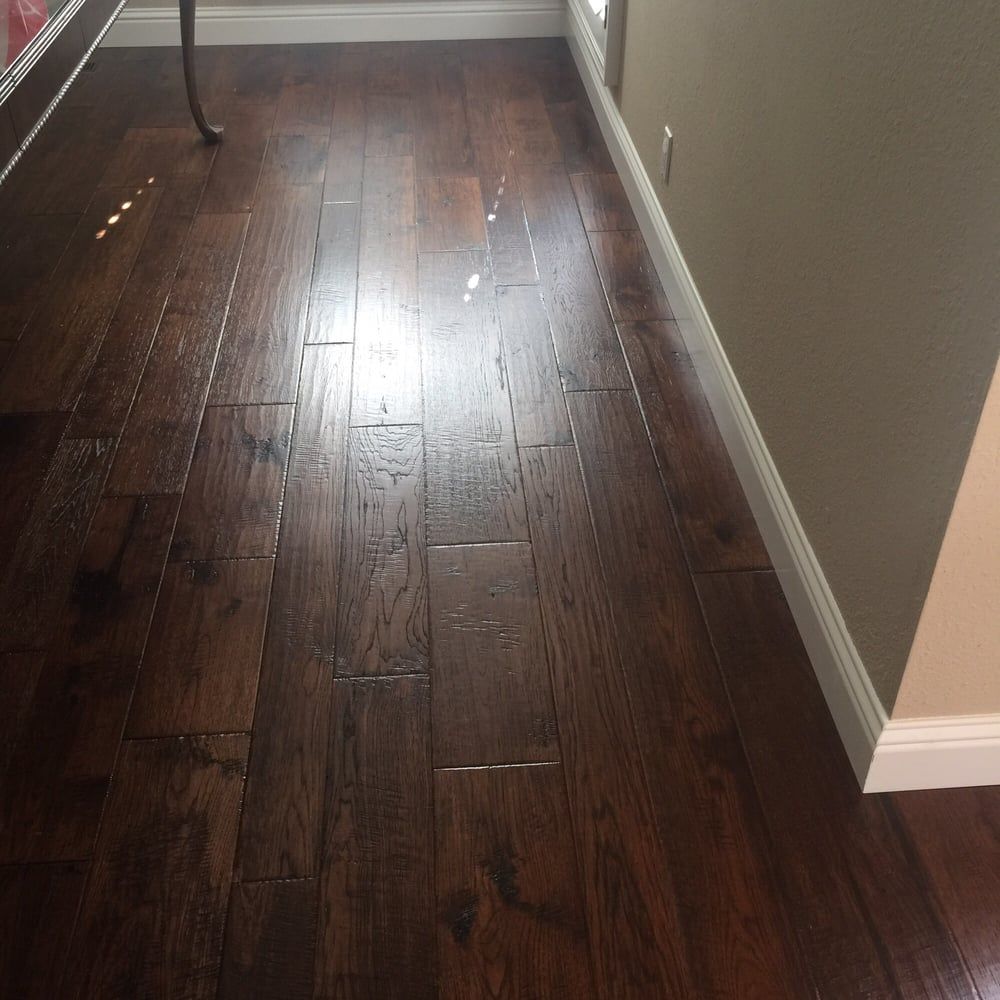 A wooden floor in a room next to a window