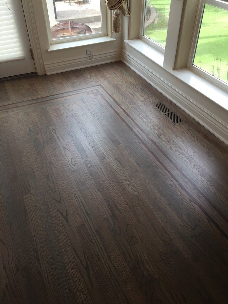 A wooden floor in a room with a window.