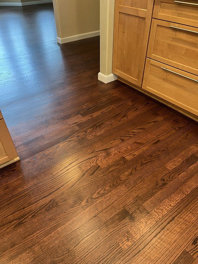 A kitchen with hardwood floors and wooden cabinets.