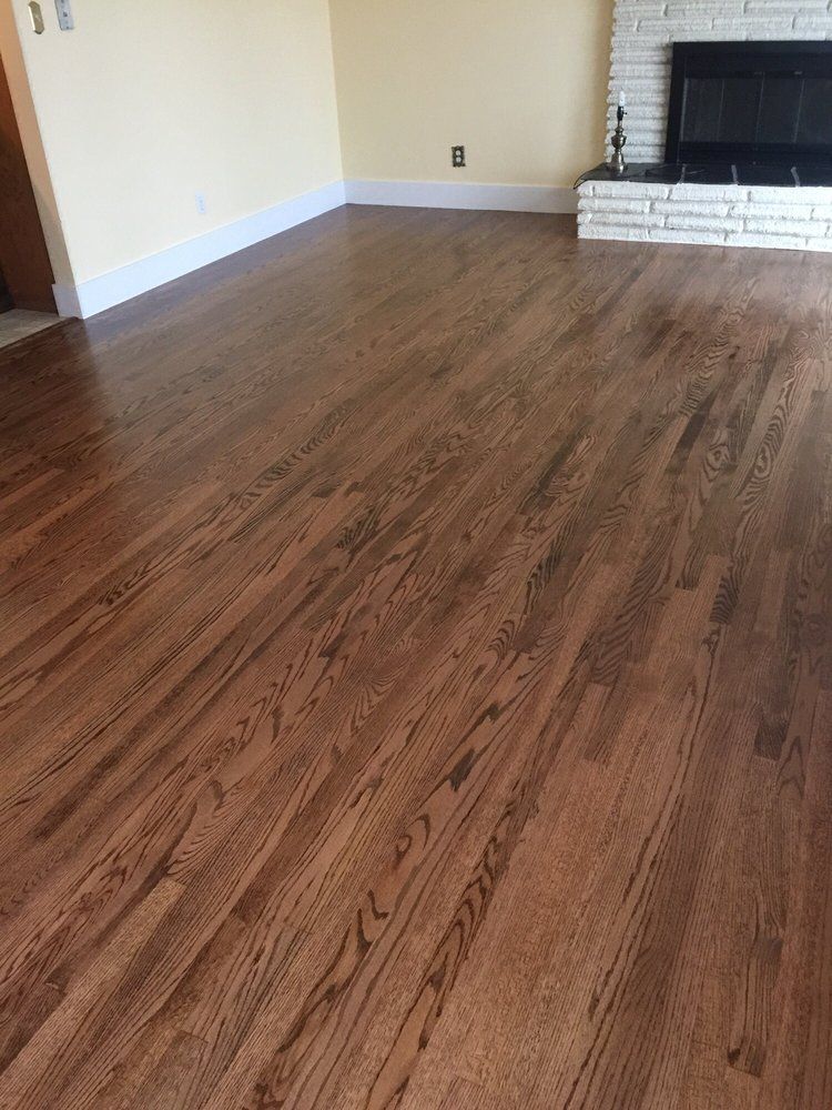 A living room with hardwood floors and a fireplace.