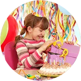 a little girl is sitting at a table with a birthday cake .