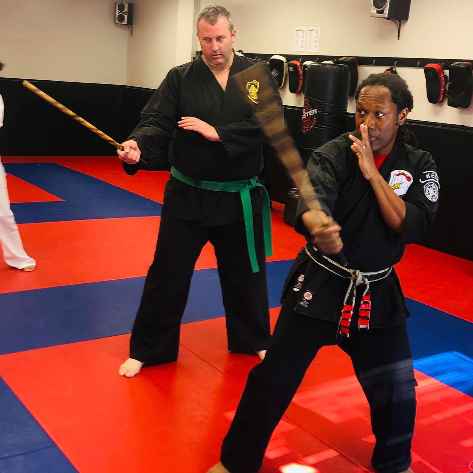 a man and a woman are practicing judo with the letter a in the background