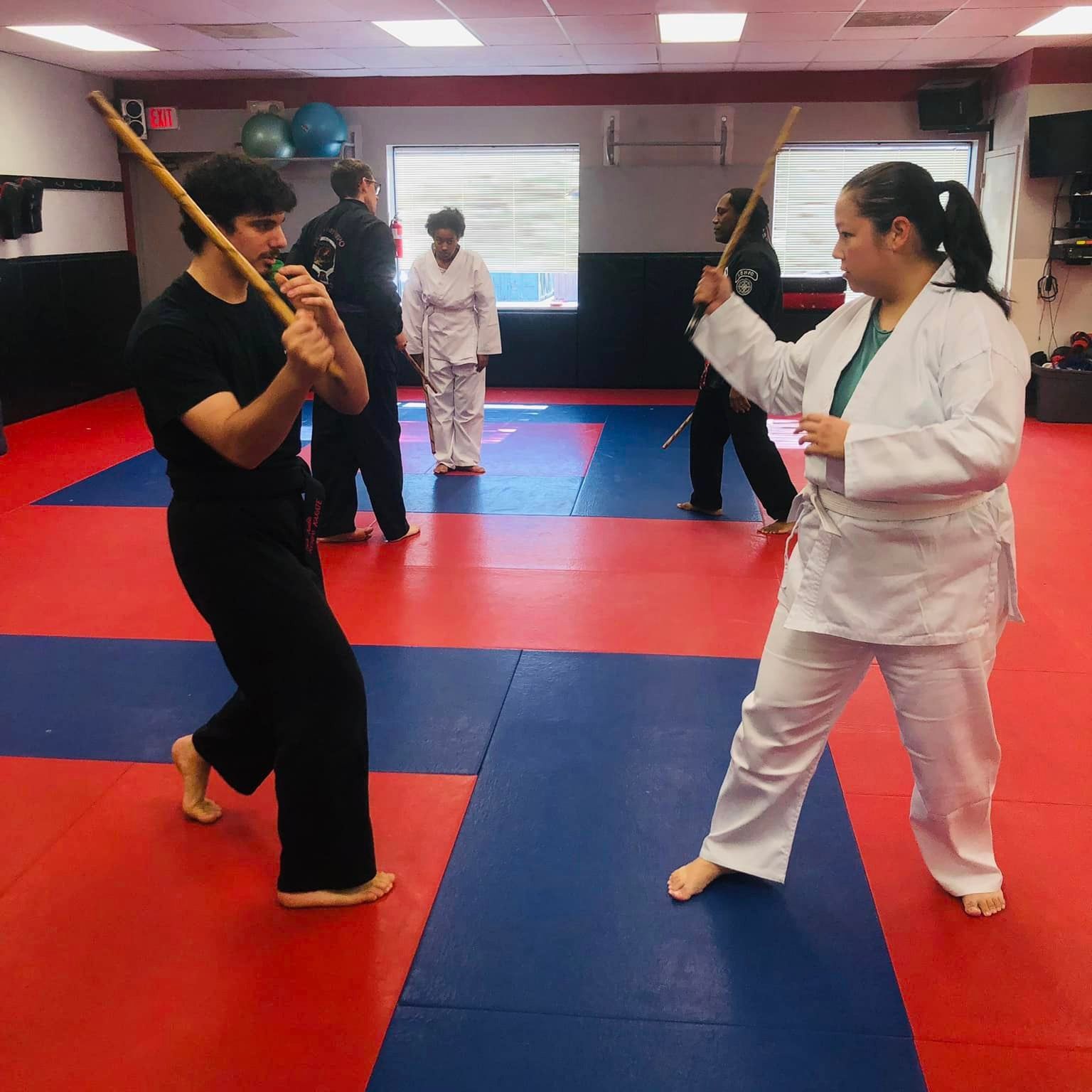 a group of people are practicing martial arts in a gym
